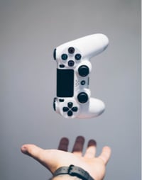 a hand tossing a playstation controller in the air